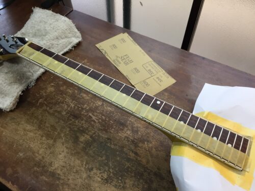 フレットの角にサンドペーパーをあてる